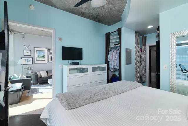 a bedroom with a bed flat screen tv and couches