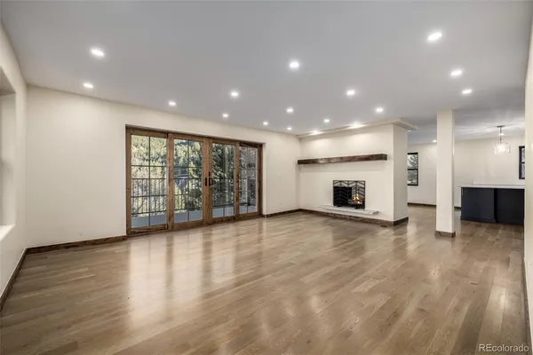 a view of empty room with wooden floor and fireplace