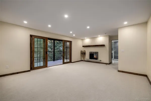 an empty room with fireplace and windows