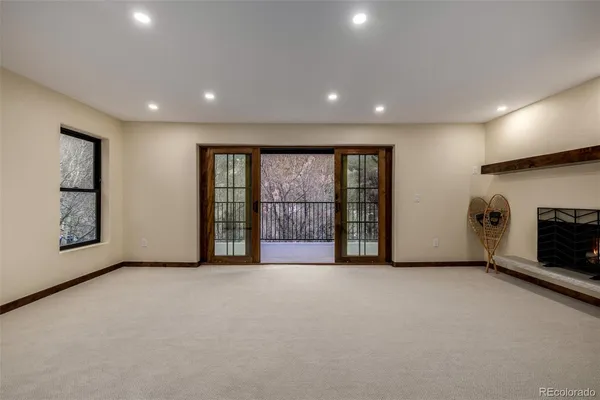a living room with furniture a large window and a fireplace