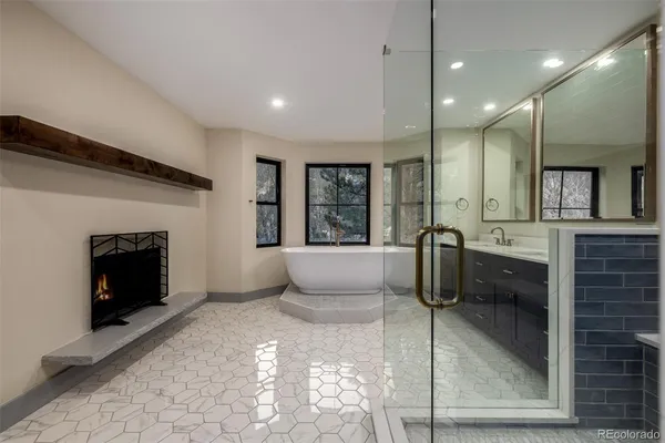 a bathroom with a tub sink shower and mirror