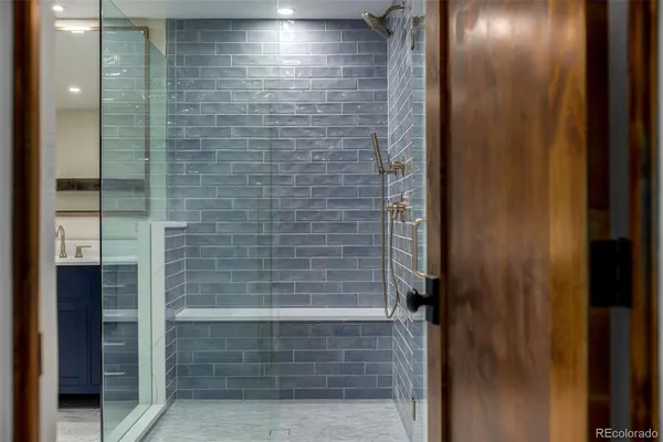 a bathroom with a sink a toilet a large mirror and shower