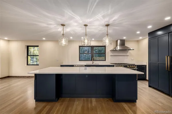 a kitchen with kitchen island a sink dishwasher a stove and a refrigerator with wooden floor