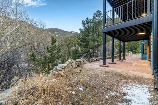 a backyard of a house with large trees and stairs