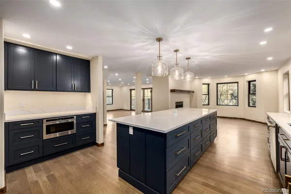 a kitchen with stainless steel appliances granite countertop a kitchen island a stove and a sink