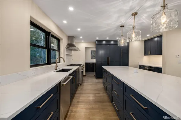 a large kitchen with stainless steel appliances lots of counter space and a sink