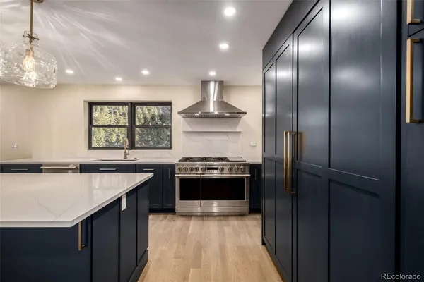 a kitchen with stainless steel appliances granite countertop a stove a refrigerator and a stove