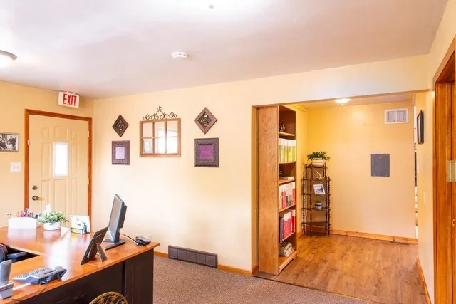 a view of a workspace with furniture and a window