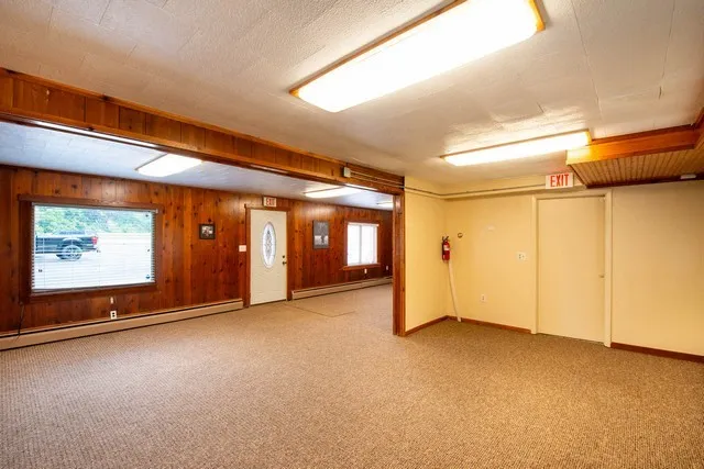 a view of an empty room with window and stairs