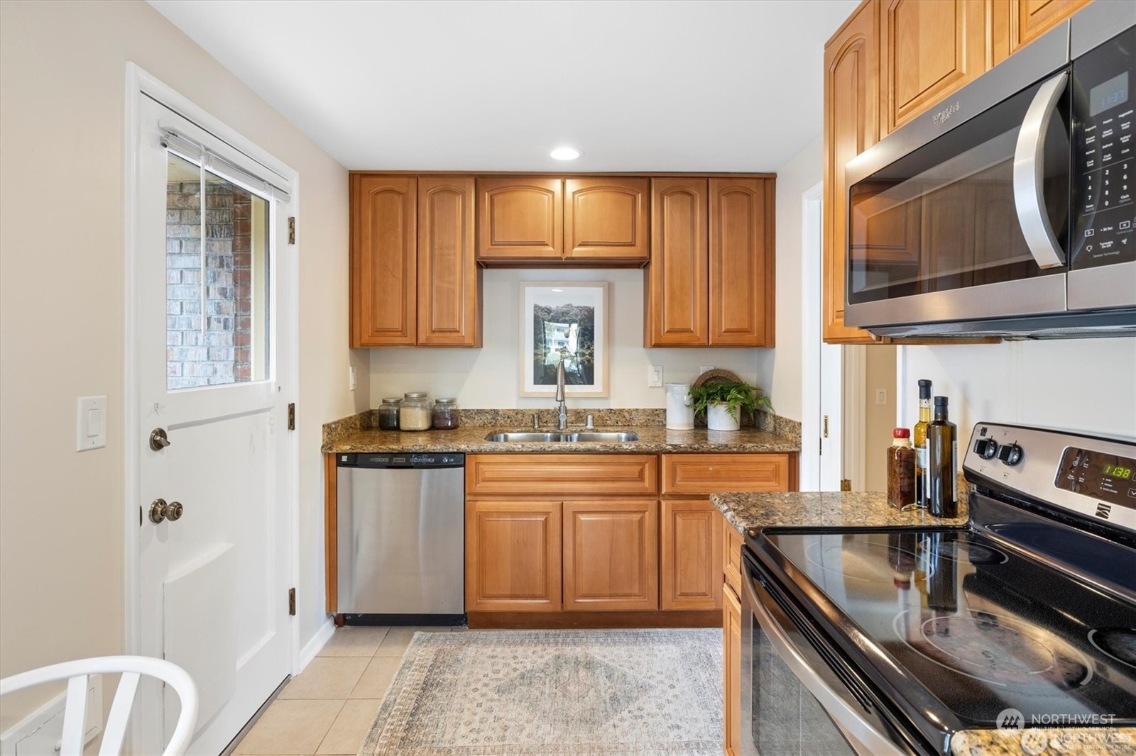 3801 Northeast 75th Street Seattle, WA 98115 - Photo 11 of 40 a kitchen with stainless steel appliances granite countertop a stove sink and cabinets