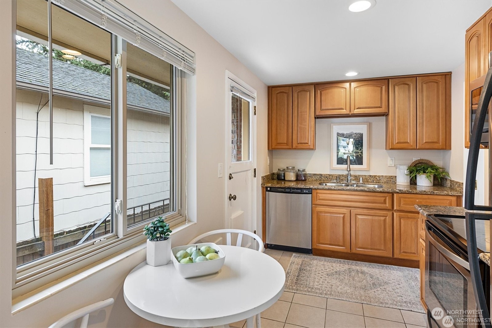 3801 Northeast 75th Street Seattle, WA 98115 - Photo 12 of 40 a kitchen with stainless steel appliances granite countertop a sink a stove a dining table and chairs