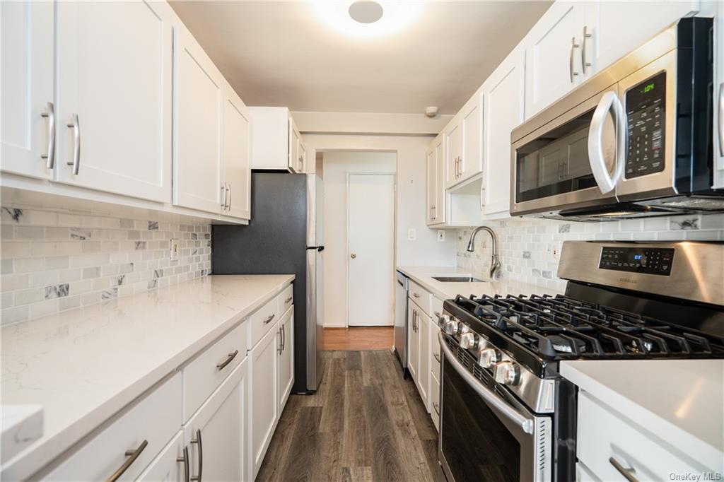 a kitchen with stainless steel appliances a sink stove and microwave