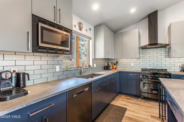 a kitchen with stainless steel appliances granite countertop a sink stove and microwave