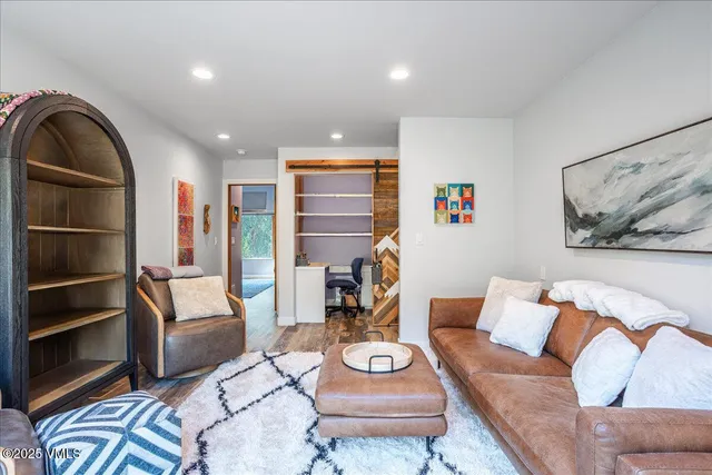 a view of a hallway with wooden floor and entryway