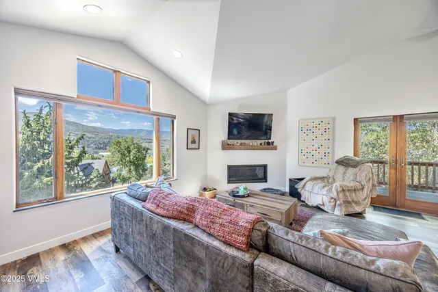 a kitchen with stainless steel appliances granite countertop a refrigerator a stove a sink a dining table and chairs