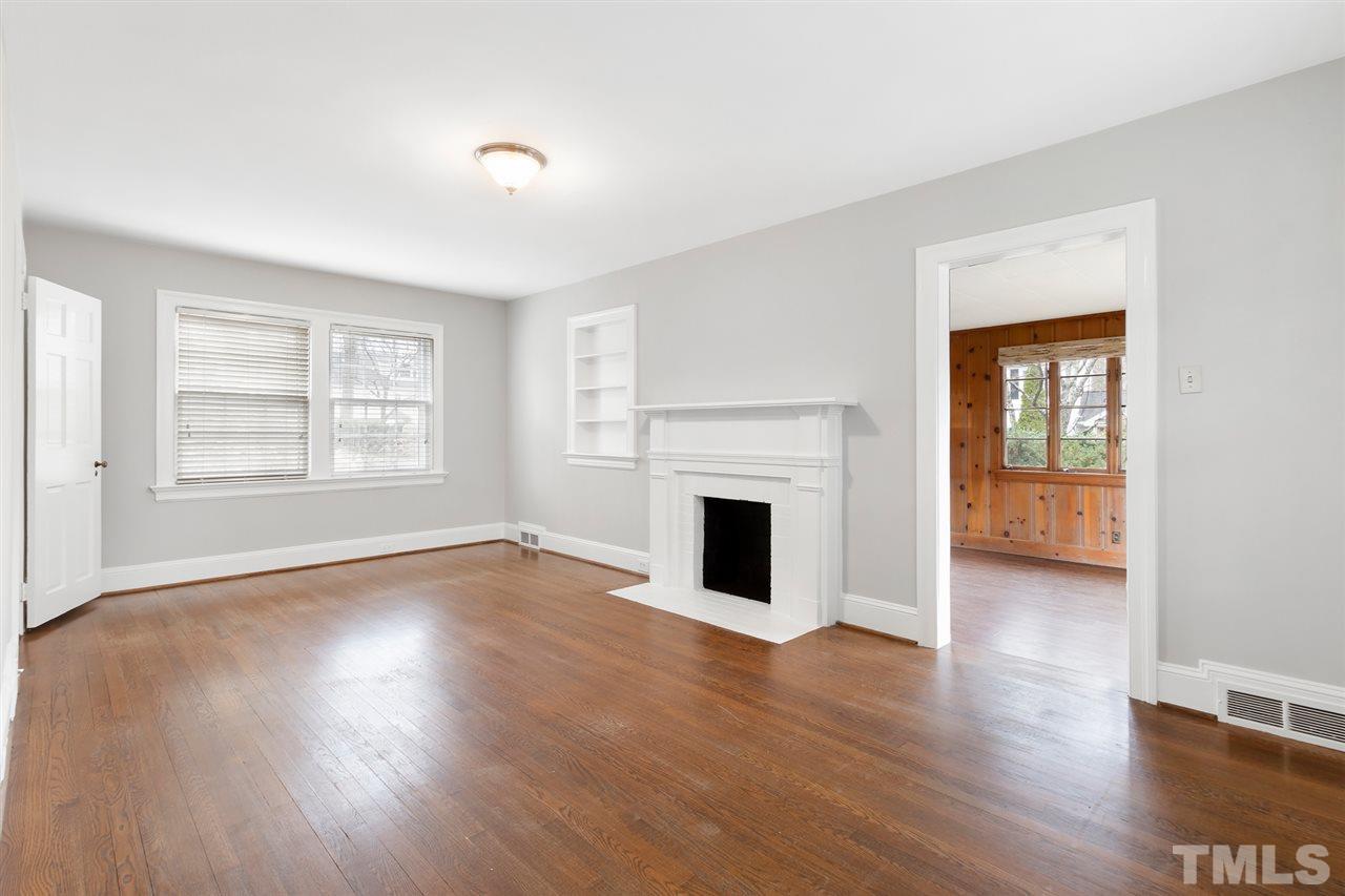 2115 Reaves Drive Raleigh, NC 27608 - Photo 5 of 26 a view of empty room with wooden floor and fireplace