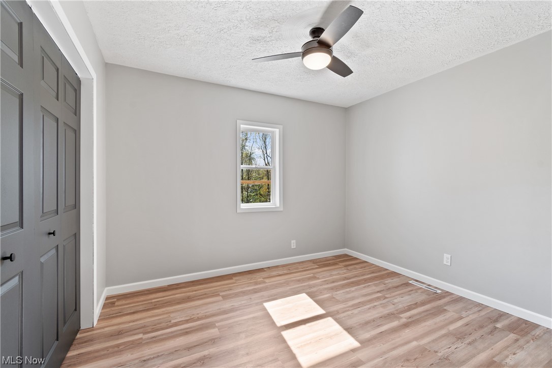 59636 Broadview Road Shadyside, OH 43947 - Photo 24 of 31 Empty room with a textured ceiling, light hardwood flooring, and ceiling fan