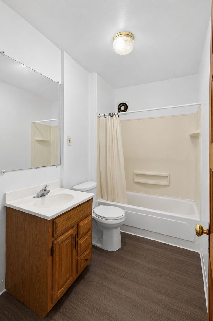 226 West Locust Street DeKalb, IL 60115 - Photo 22 of 40 a bathroom with a sink a toilet and shower