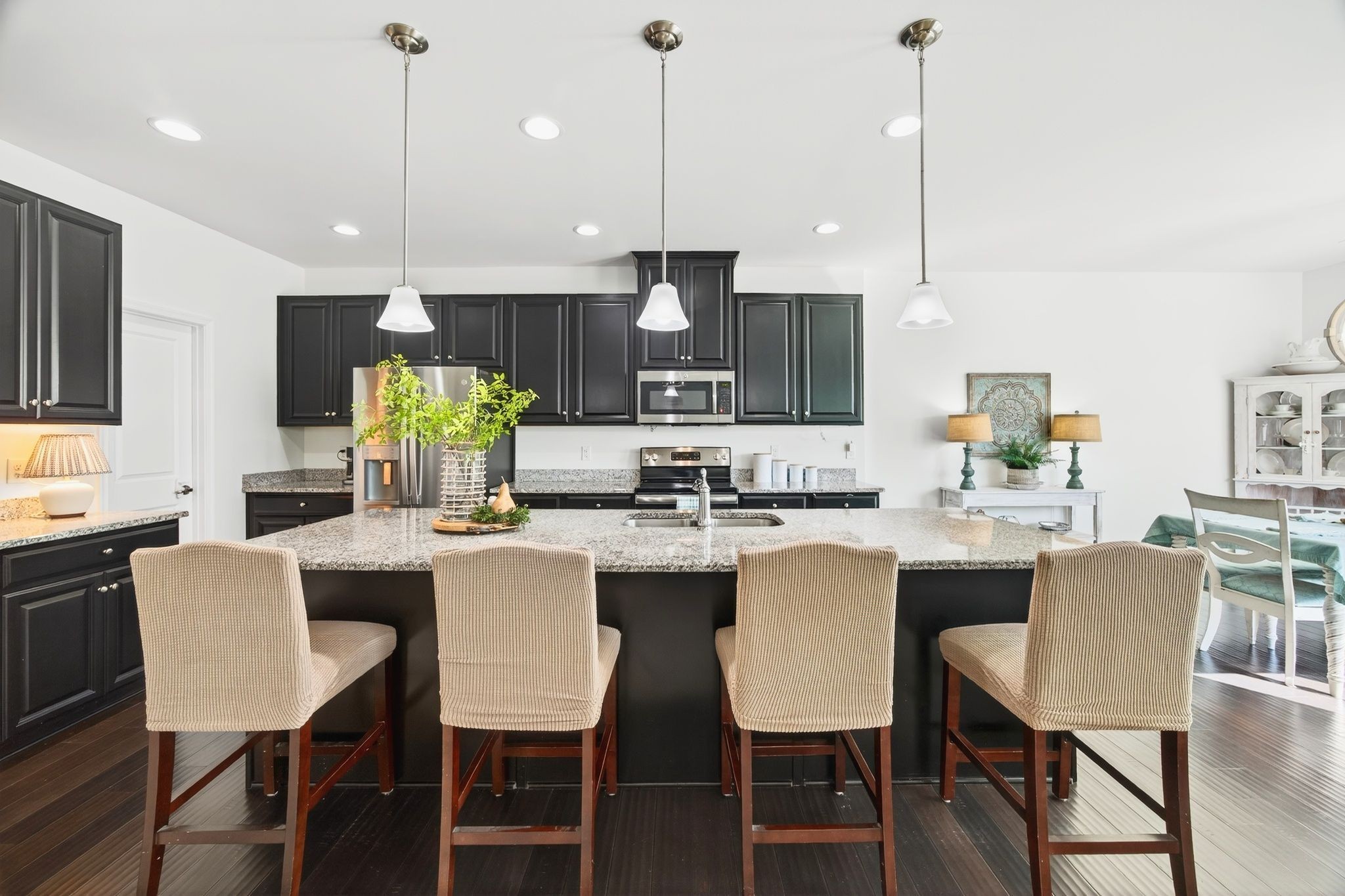 423 Heroit Drive Spring Hill, TN 37174 - Photo 18 of 43 a kitchen with stainless steel appliances granite countertop a dining table chairs stove and white cabinets