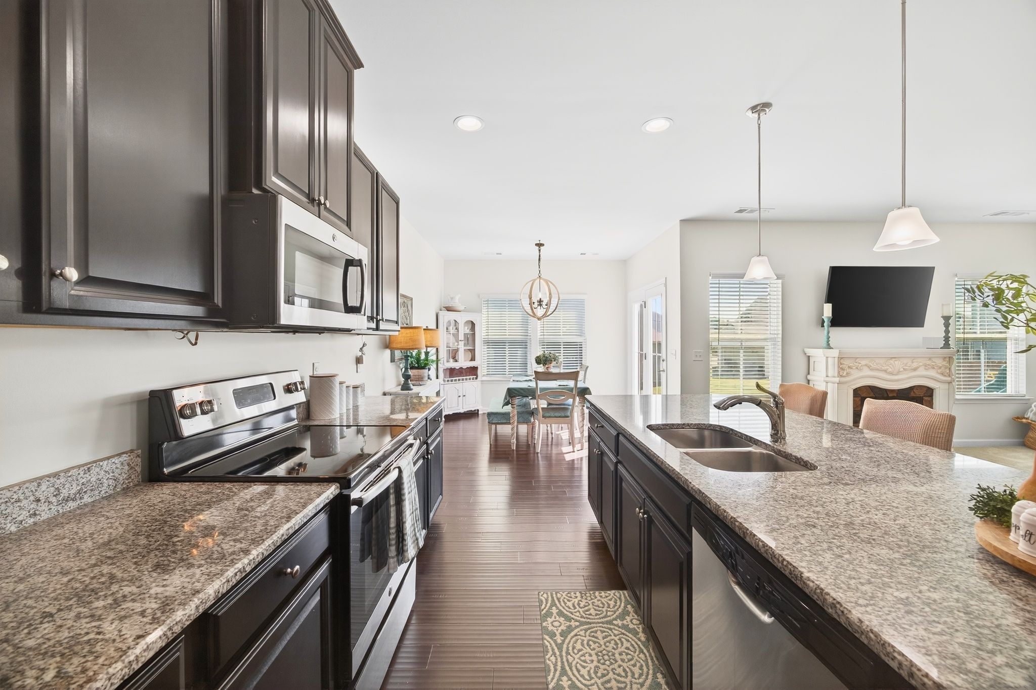 423 Heroit Drive Spring Hill, TN 37174 - Photo 24 of 43 a kitchen with stainless steel appliances granite countertop a stove a sink and a microwave