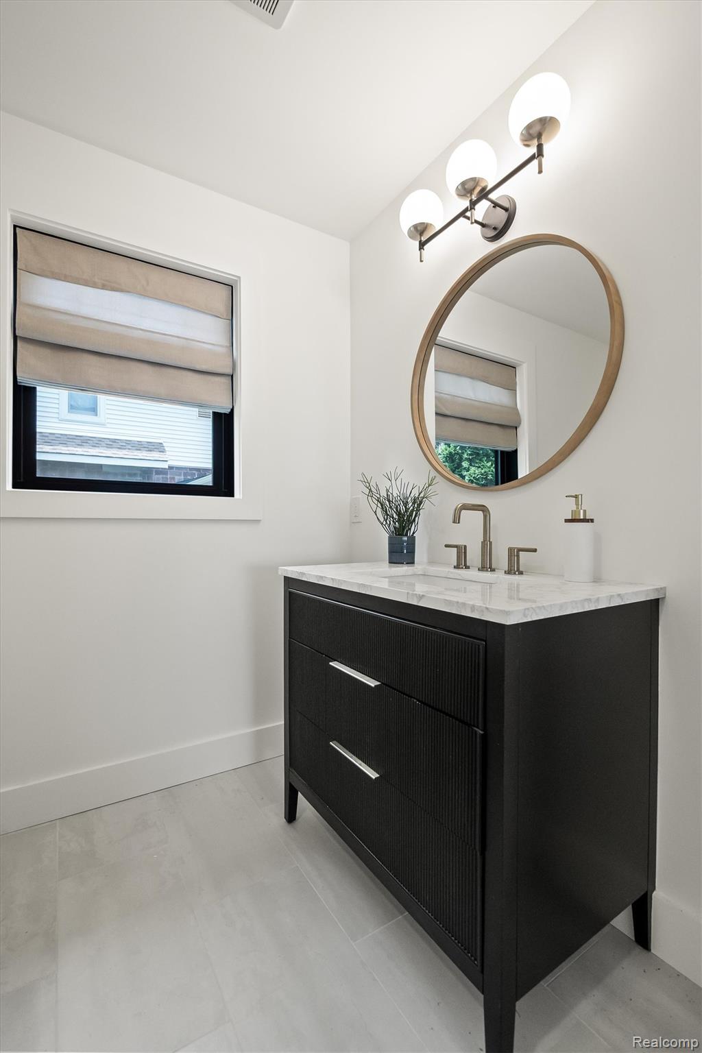 347 Highland Avenue Rochester, MI 48307 - Photo 23 of 59 Bathroom featuring a dark wood-finish vanity with a light countertop, a circular mirror, and a contemporary three-light fixture