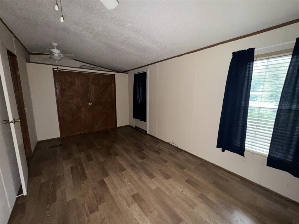 9949 Green Tree Lane Wills Point, TX 75169 - Photo 6 of 9 an empty room with wooden floor and windows
