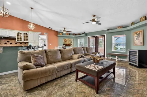 a living room with furniture a large window and a flat screen tv