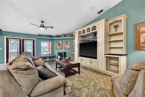 a living room with furniture ceiling fan and a flat screen tv