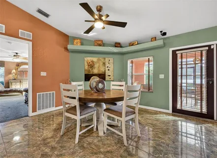 a view of a dining room with furniture and a ceiling fan