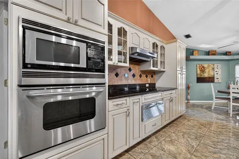 a kitchen with stainless steel appliances granite countertop a stove microwave and cabinets
