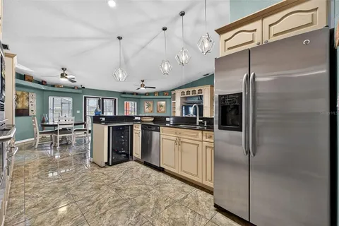 a kitchen with stainless steel appliances granite countertop a refrigerator a stove and a sink with cabinets