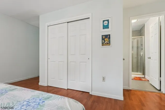 a view of a bedroom with wooden floor and bathroom