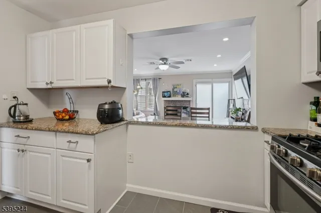 a kitchen with granite countertop a white cabinets and stainless steel appliances
