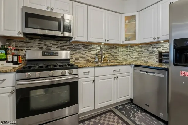 a kitchen with cabinets stainless steel appliances and a sink