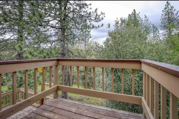 a view of balcony with wooden floor and fence