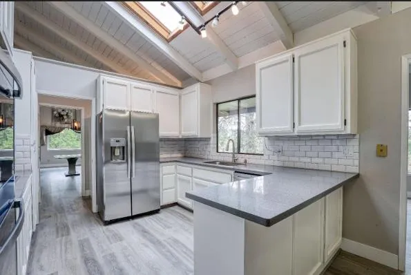 a kitchen with stainless steel appliances granite countertop a refrigerator a sink and a dishwasher