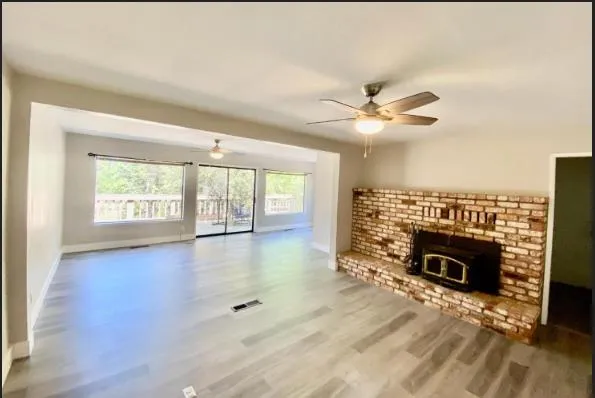 wooden floor fireplace and windows in an empty room