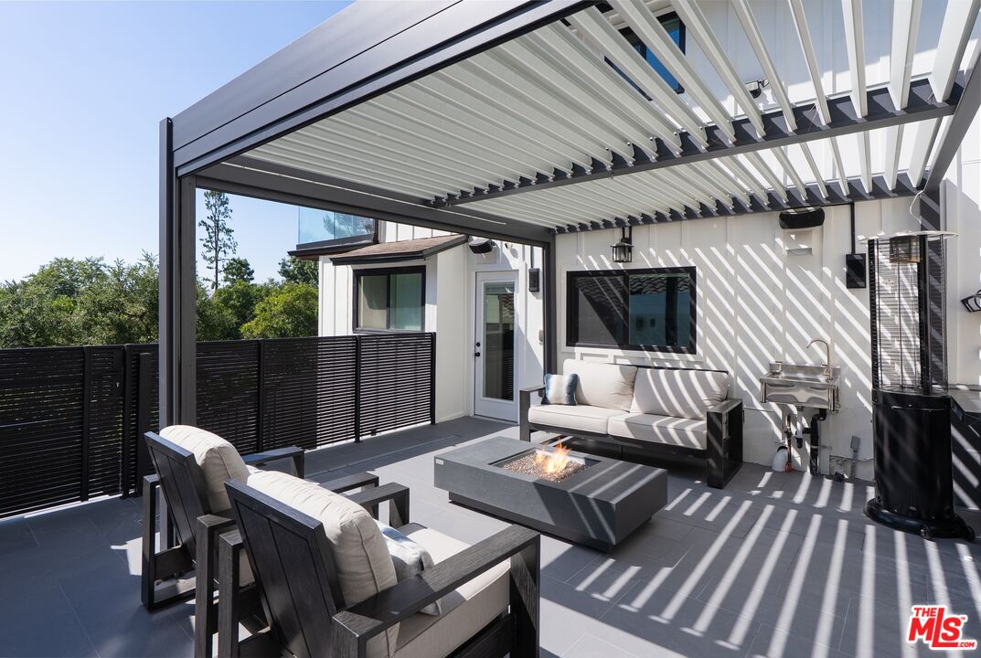 4118 Oak Hollow Road Calabasas, CA 91302 - Photo 28 of 55 a view of a patio with table and chairs with wooden floor and fence