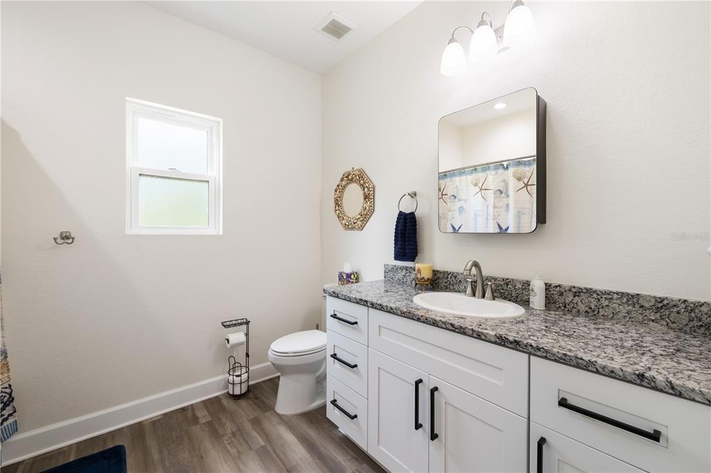 5149 Southwest 119th Road Lake Butler, FL 32054 - Photo 28 of 40 a bathroom with a granite countertop toilet sink and mirror