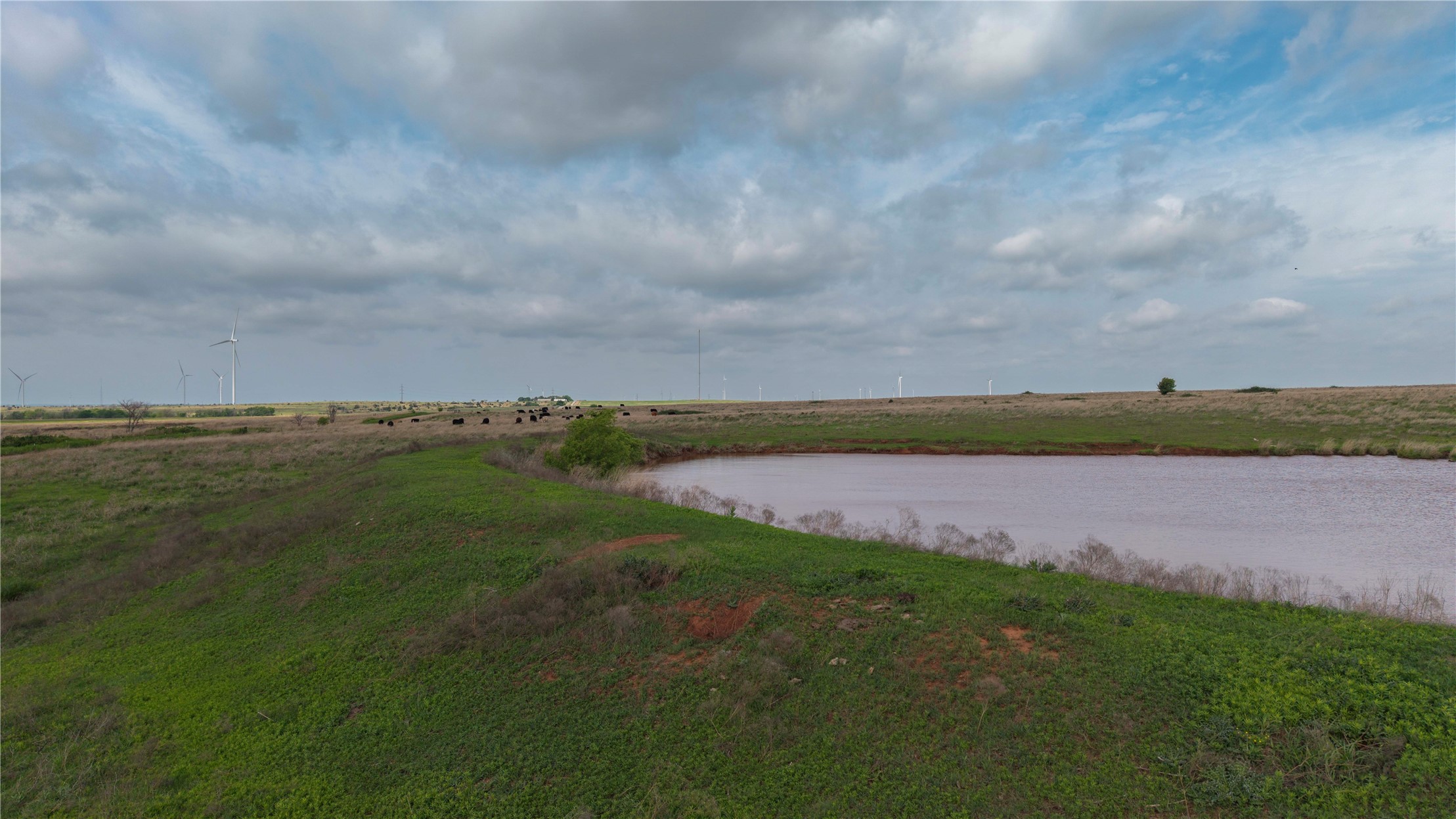42 East 4500 Road Morrison, OK 73061 - Photo 2 of 37 Expansive agricultural property featuring open acreage with established drainage infrastructure, including a lined irrigation canal bordered by manicured grass embankments