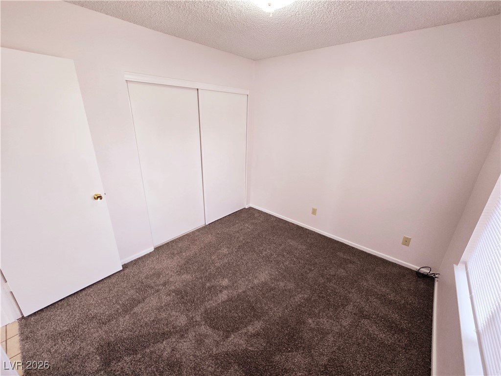 1108 Meadbrook Street Las Vegas, NV 89110 - Photo 11 of 41 Unfurnished bedroom featuring carpet flooring, a textured ceiling, and a closet