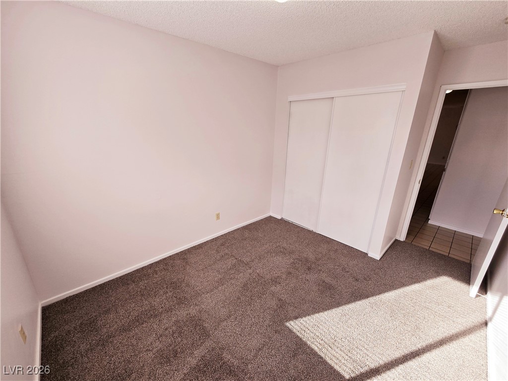 1108 Meadbrook Street Las Vegas, NV 89110 - Photo 13 of 41 Unfurnished bedroom with carpet, a textured ceiling, and a closet