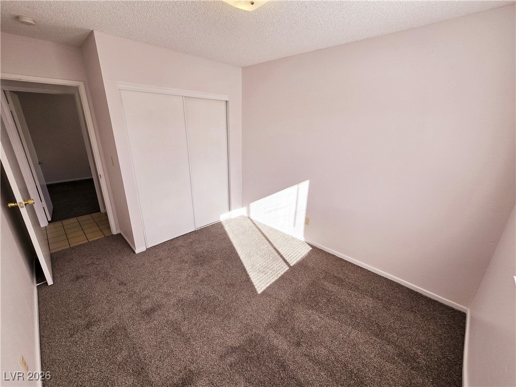 1108 Meadbrook Street Las Vegas, NV 89110 - Photo 5 of 41 Unfurnished bedroom with a textured ceiling, a closet, and carpet flooring