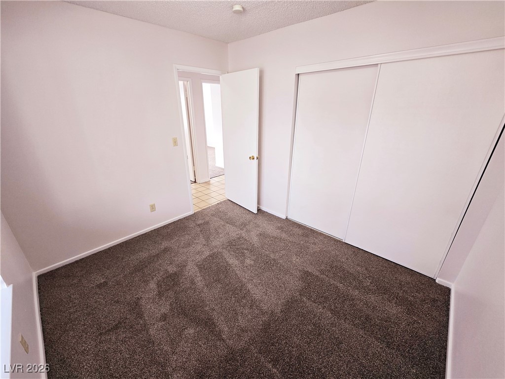 1108 Meadbrook Street Las Vegas, NV 89110 - Photo 8 of 41 Unfurnished bedroom featuring a textured ceiling, carpet flooring, and a closet