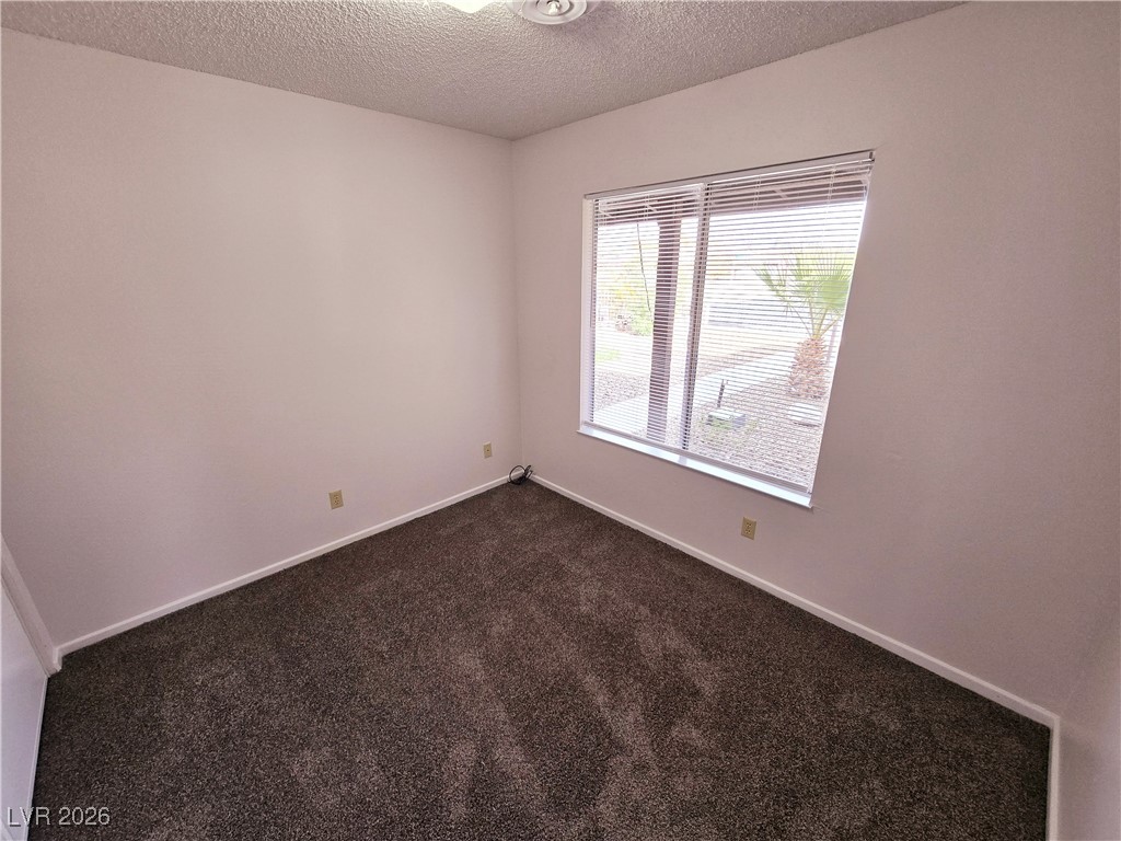 1108 Meadbrook Street Las Vegas, NV 89110 - Photo 10 of 41 Spare room featuring a textured ceiling and dark carpet