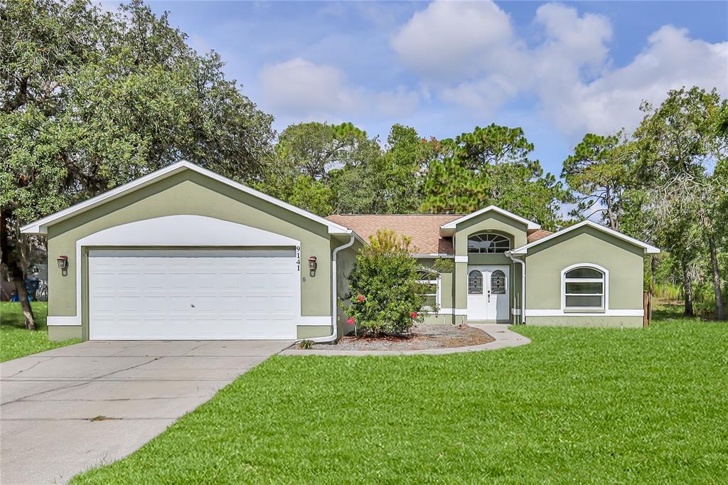 9141 Mavis Road Spring Hill, FL 34613 - Photo 1 of 1 a front view of a house with a yard and garage