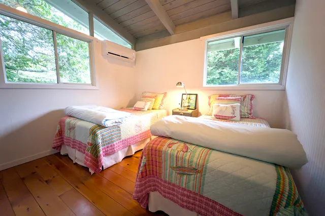 a bedroom with two beds and a large window