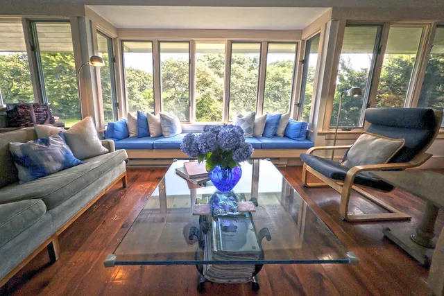 a living room with furniture and floor to ceiling windows