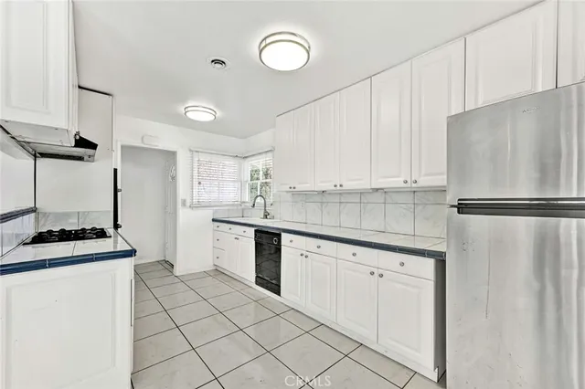 a kitchen with white cabinets and appliances