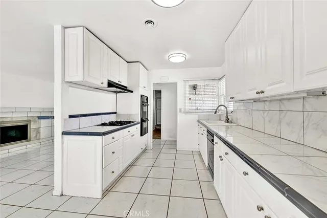a kitchen with granite countertop a sink and a stove top oven